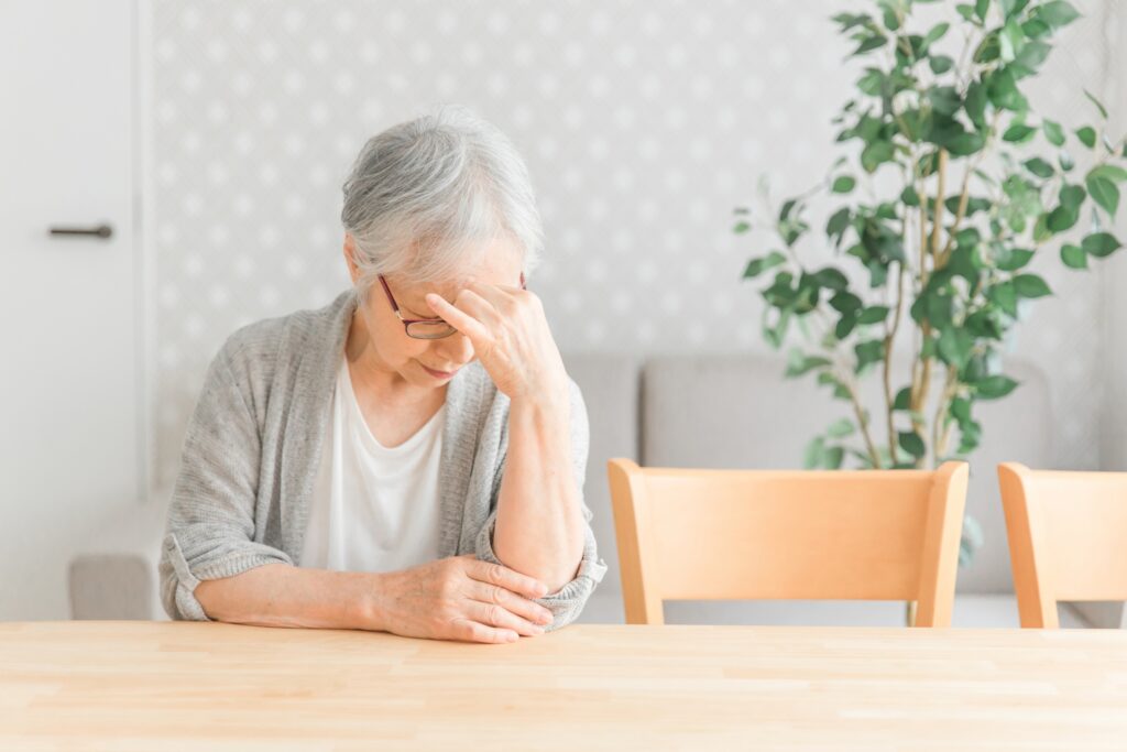 ひとりで考え込む高齢の女性