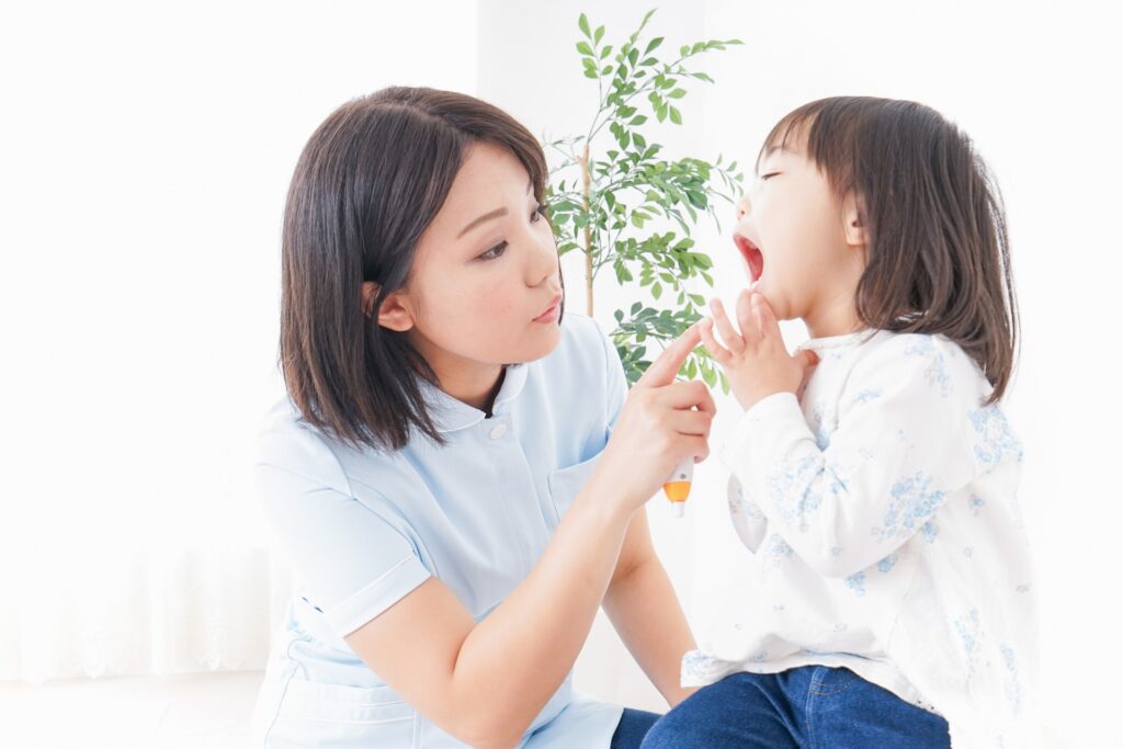 子どもの口の中を確認する保護者