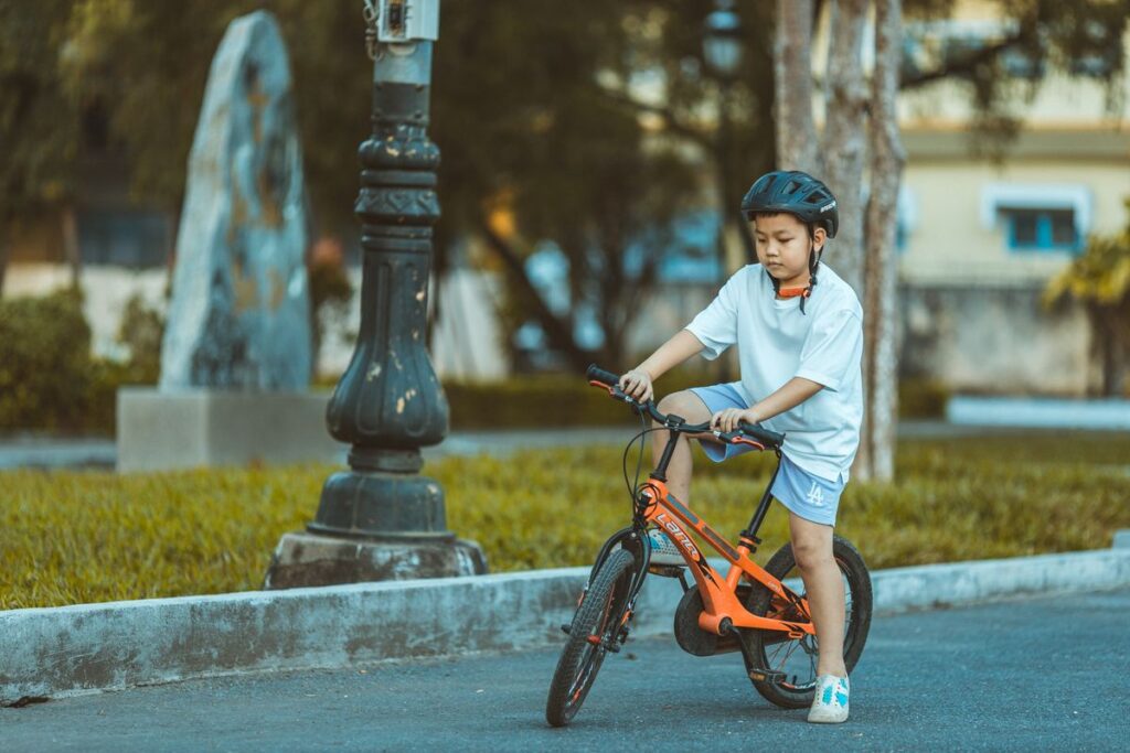 ヘルメットをかぶって自転車に乗る子ども